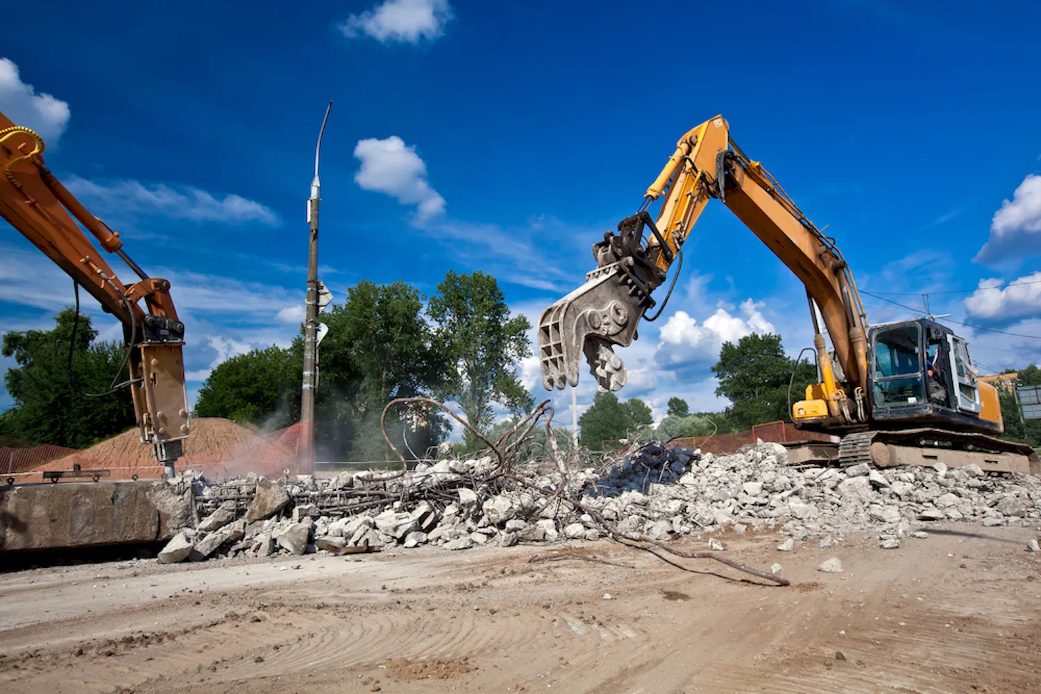 Excavators clearing a site after a building demolition